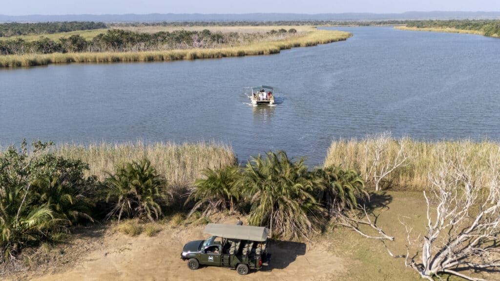 game vehicle parked in front of lake with boat floating on it