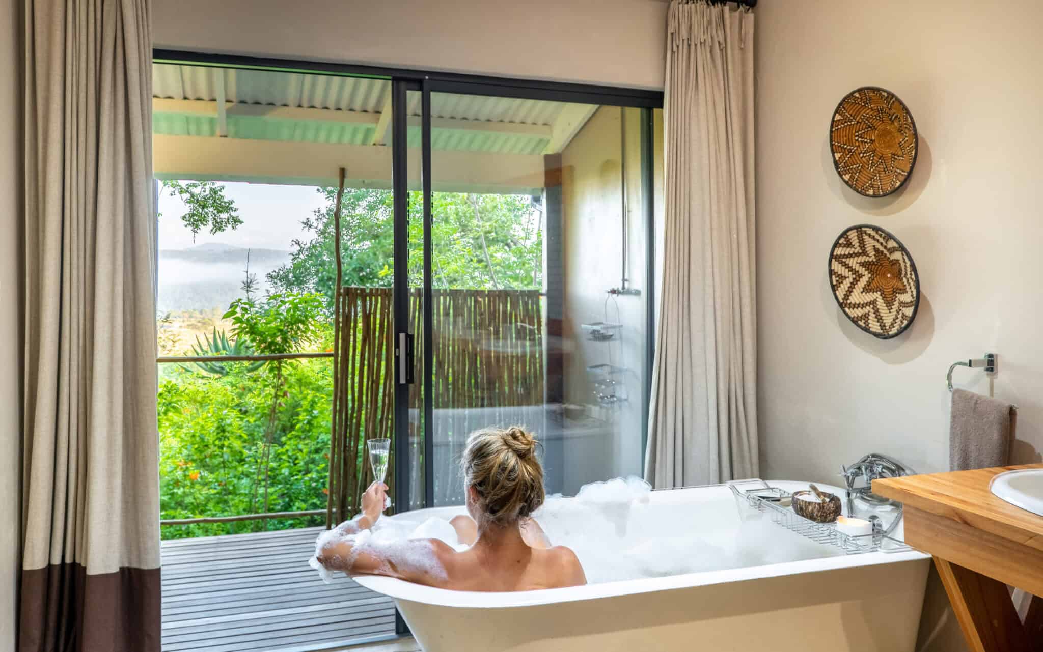 lady sitting in bathtub looking out into nature