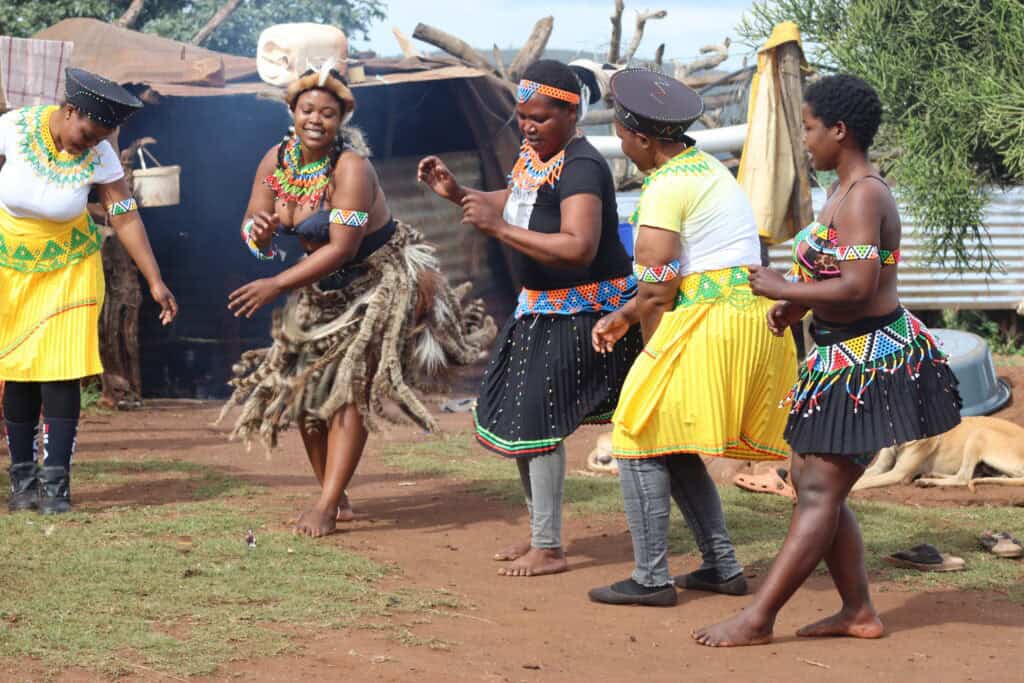 A vibrant Zulu cultural dance performance during a local community tour arranged by Leopard Mountain Safari Lodge.